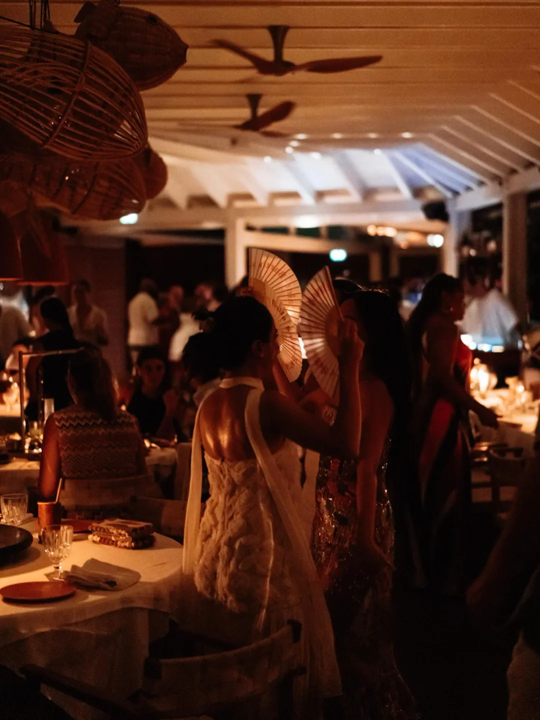 Sella restaurant's warm ambiance with decorative lamps and patrons enjoying the evening in the city.