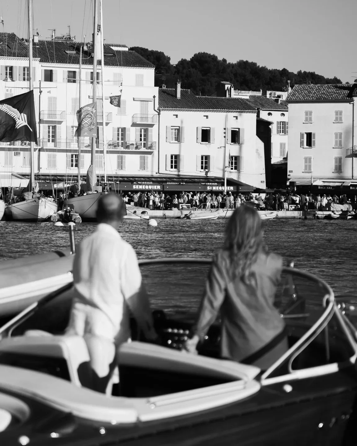 Senequier restaurant exterior facade in Saint-Tropez overlooking a busy harbor with boats.