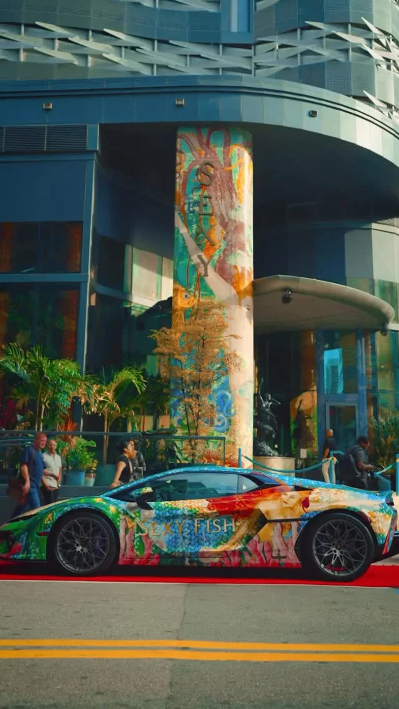 Customized Lamborghini with Sexy Fish branding parked outside the restaurant in the city