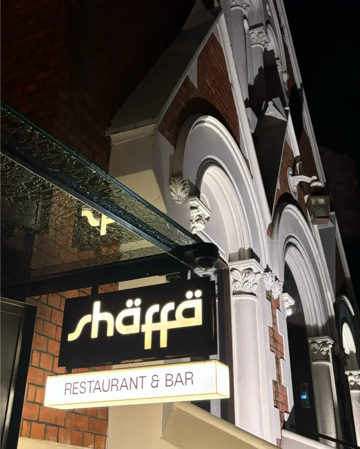Shaffa restaurant and bar sign in Sydney, illuminated at night, with architectural details.
