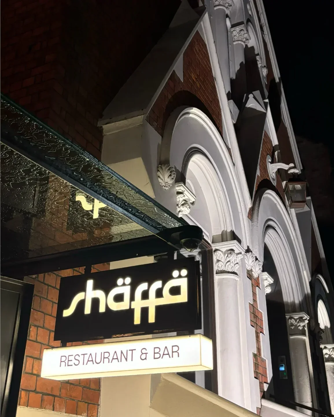 Shaffa restaurant and bar sign in Sydney, illuminated at night, with architectural details.