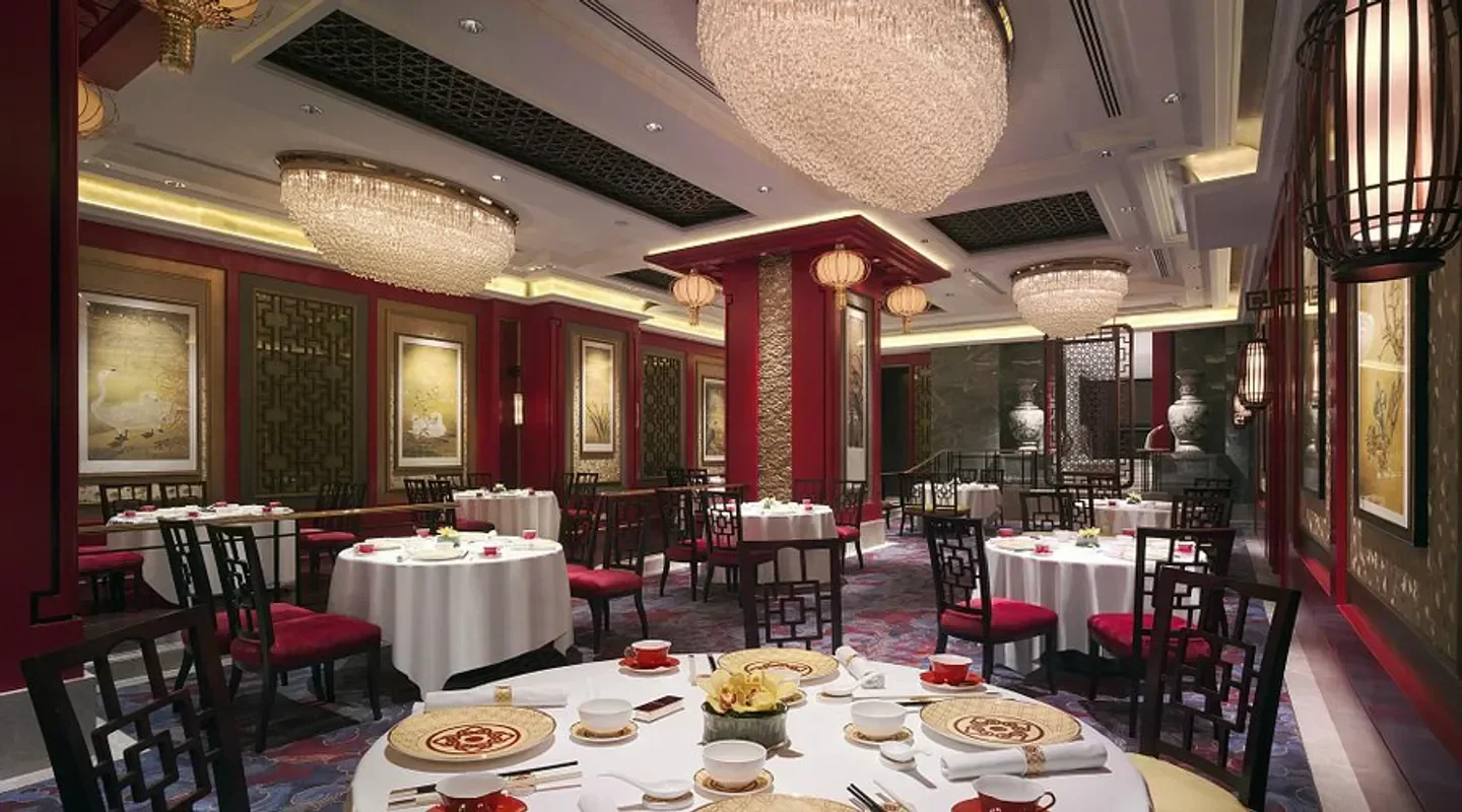 Elegant dining room at Shang Palace - Hong Kong with chandeliers and red accents.