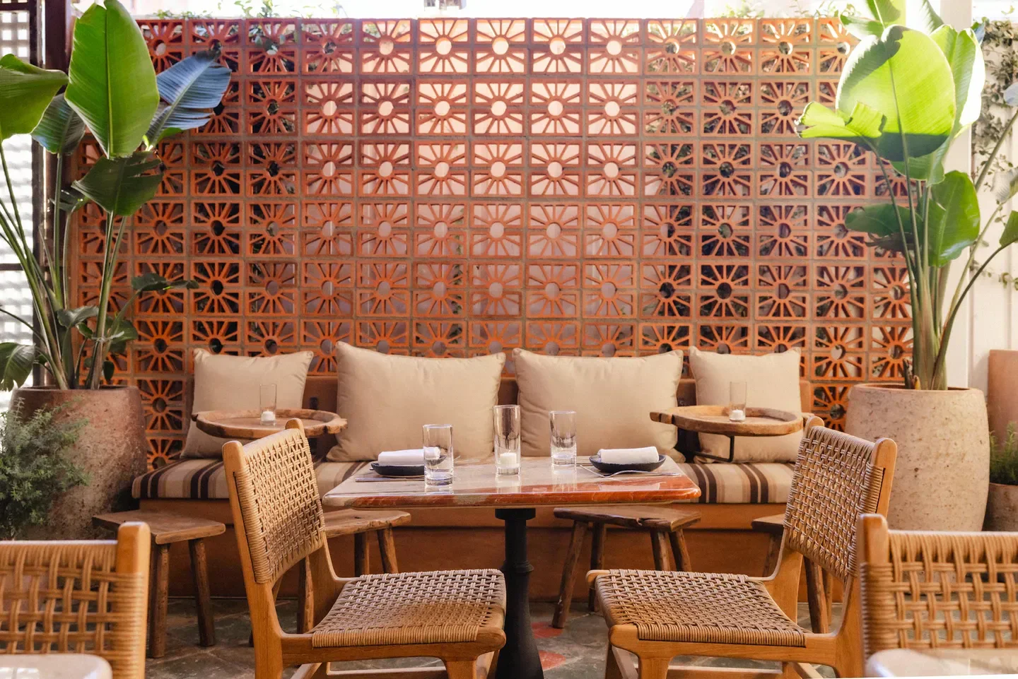 Cozy dining area at Si! Mon restaurant in Los Angeles, featuring unique brickwork and plants.