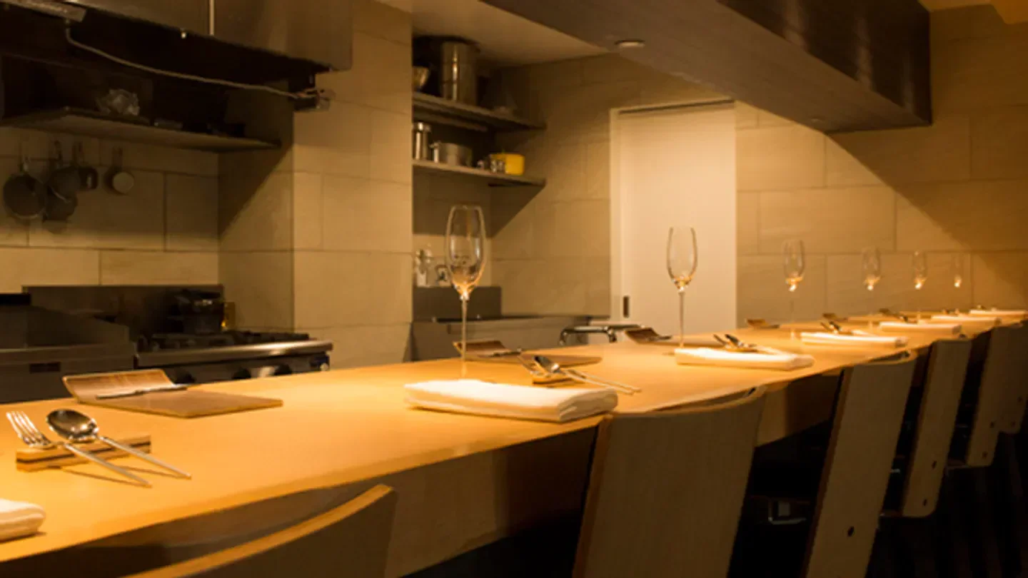 Interior view of the Simplicité restaurant in Tokyo, featuring bar seating and tableware.