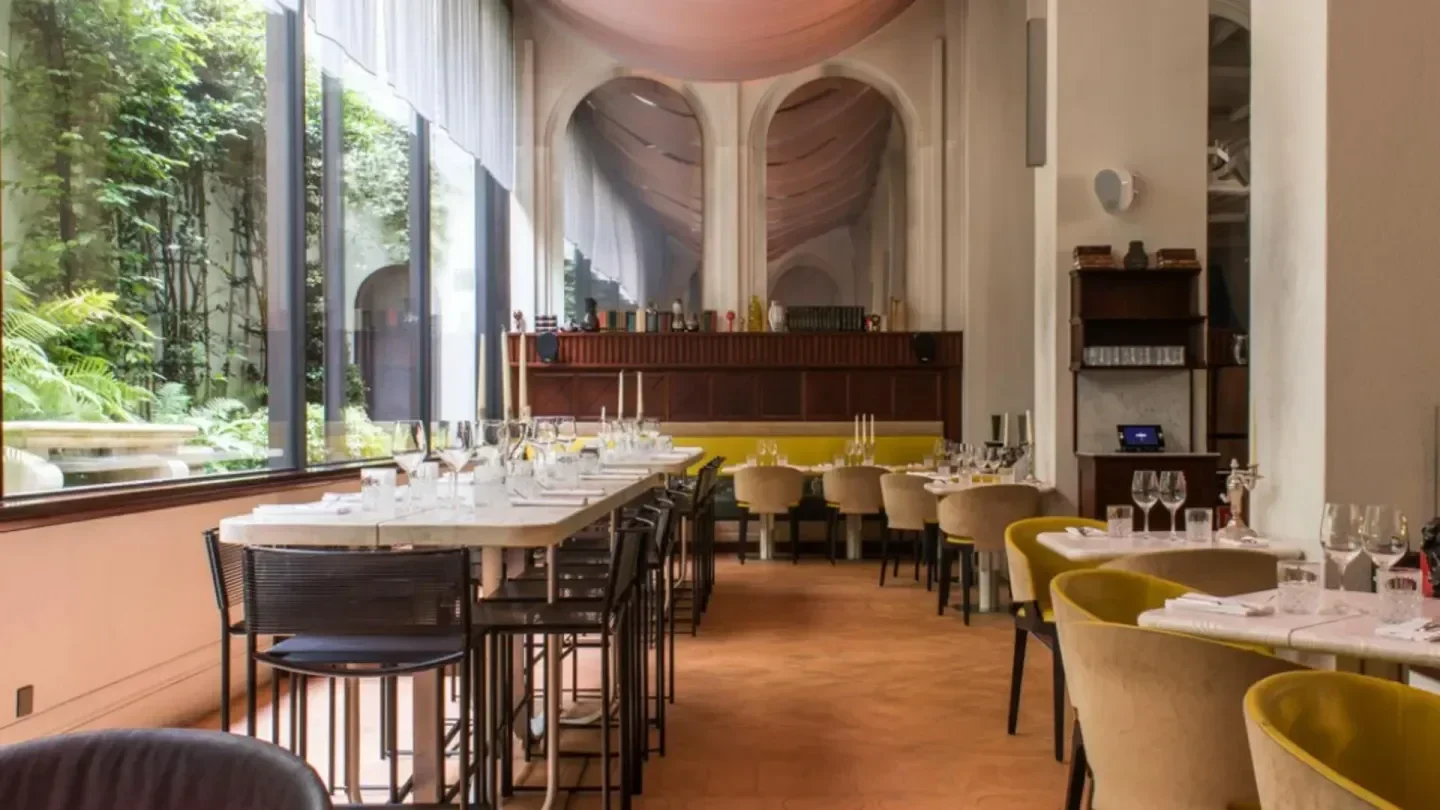 Elegant interior of Sinner restaurant in Paris, featuring stylish decor and lush greenery.