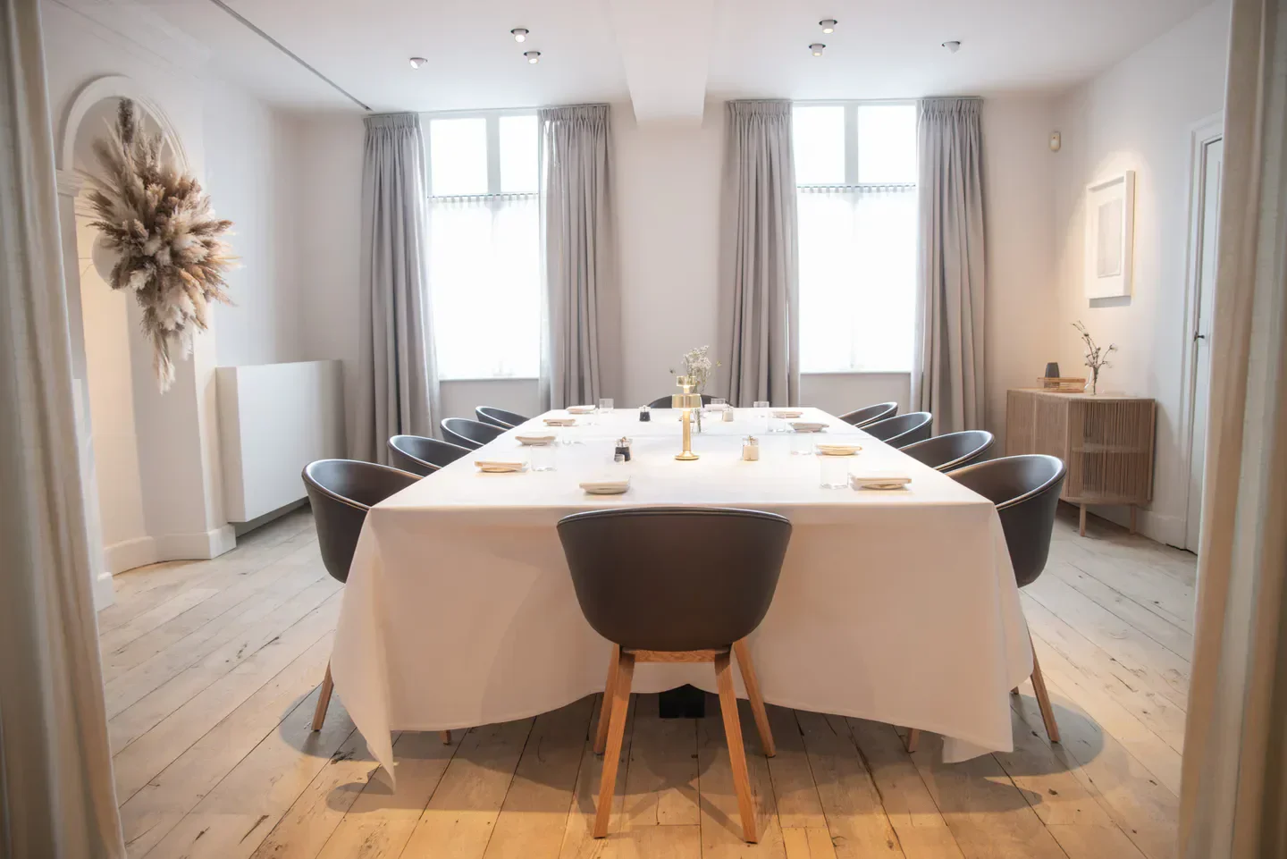 Elegant dining room at Sir Kwinten restaurant in Brussels, with a long table setting.
