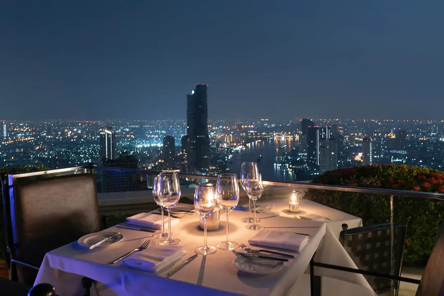 Romantic dinner setting at Sirocco restaurant in Bangkok, overlooking the city lights at night.