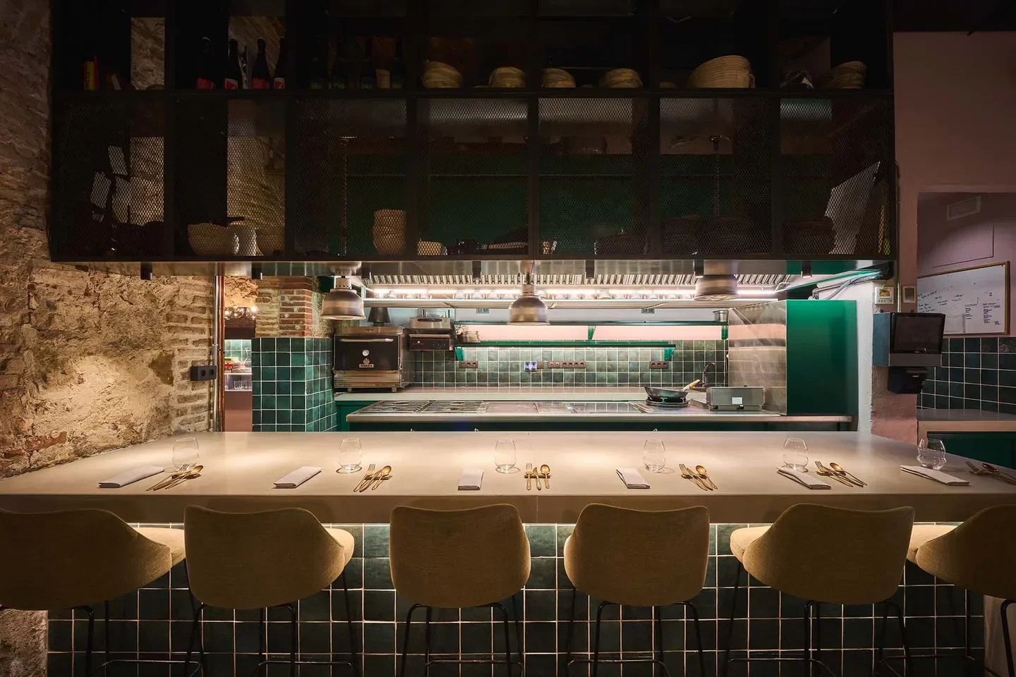Interior view of Slow & Low restaurant in Barcelona, with bar seating and kitchen area.