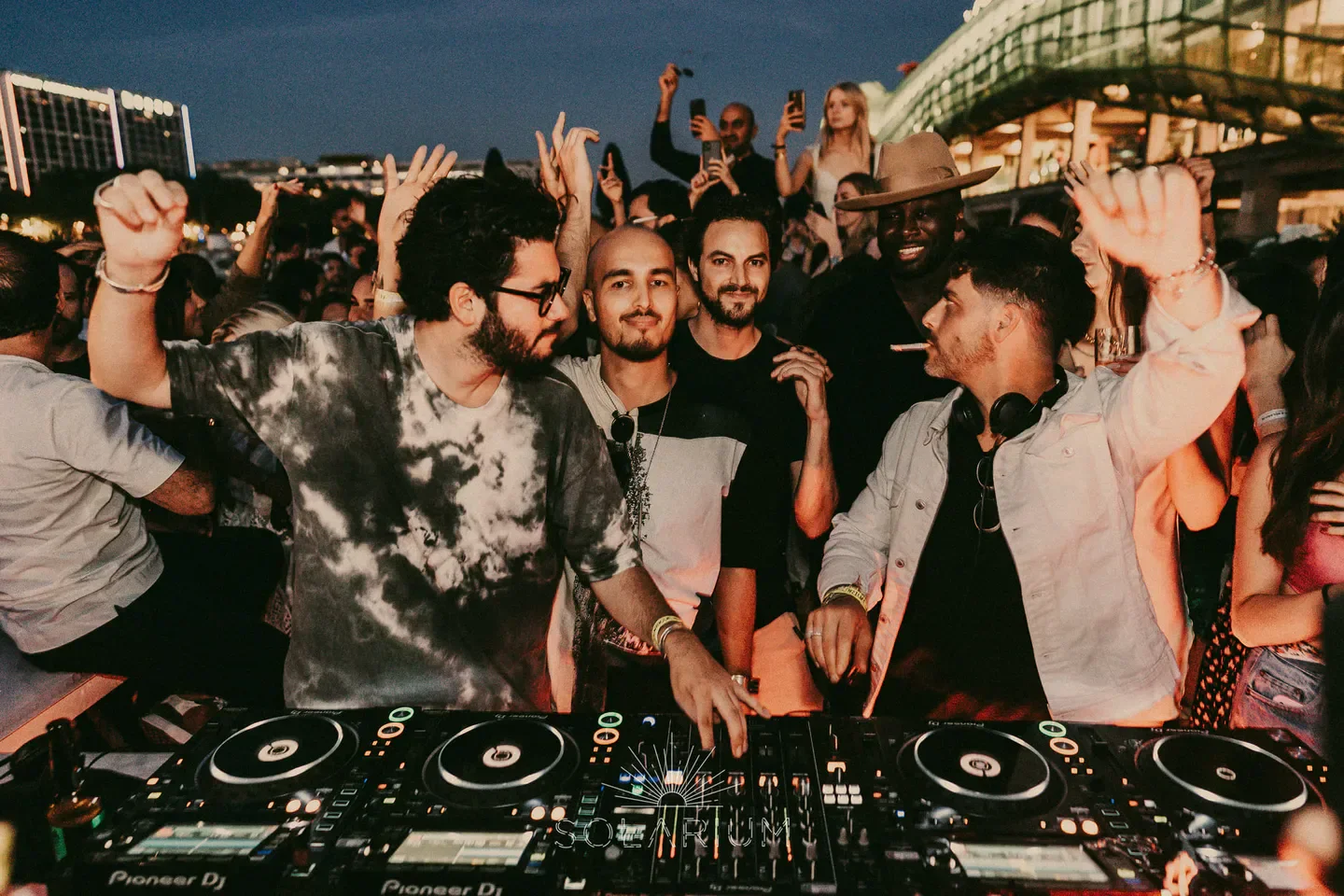 Energetic crowd at Solarium nightclub in Paris, dancing with DJ in front
