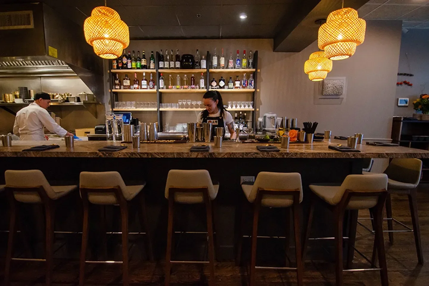 Stylish bar at Somaek restaurant in Boston, with seating and a well-stocked bar.