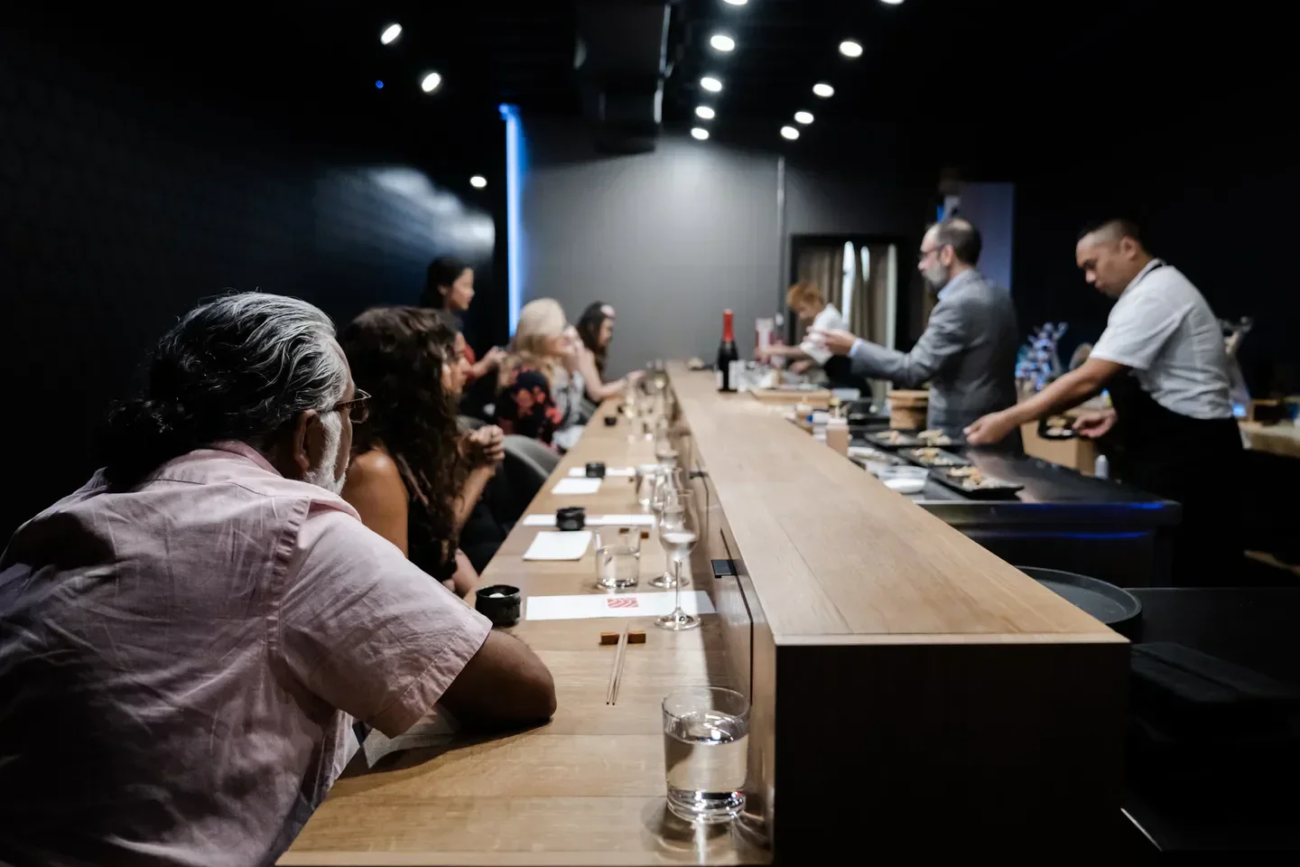 Dining at Soseki Orlando: Guests at the sushi counter while chefs prepare the food.