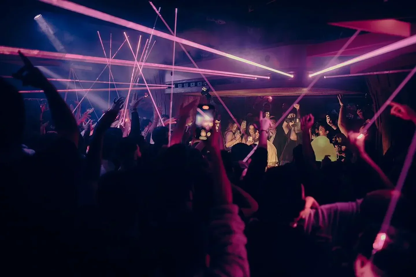 Energetic crowd at Soubois nightclub in Montreal, illuminated by laser beams and lights.