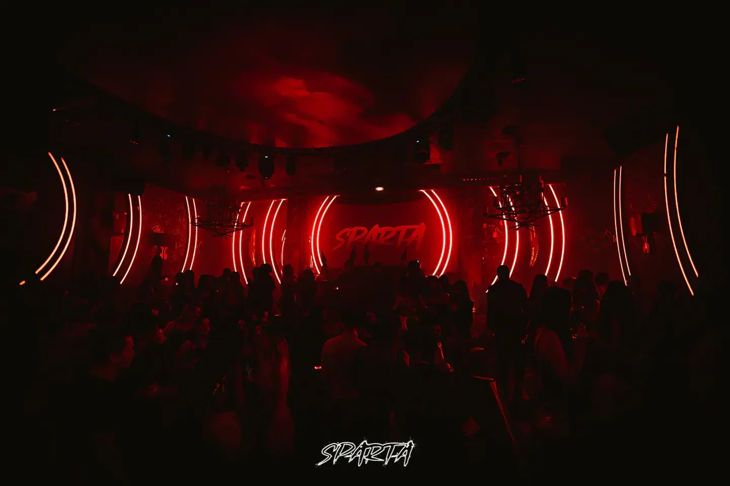 Inside Sparta nightclub in Paris, with neon lights and a lively crowd.