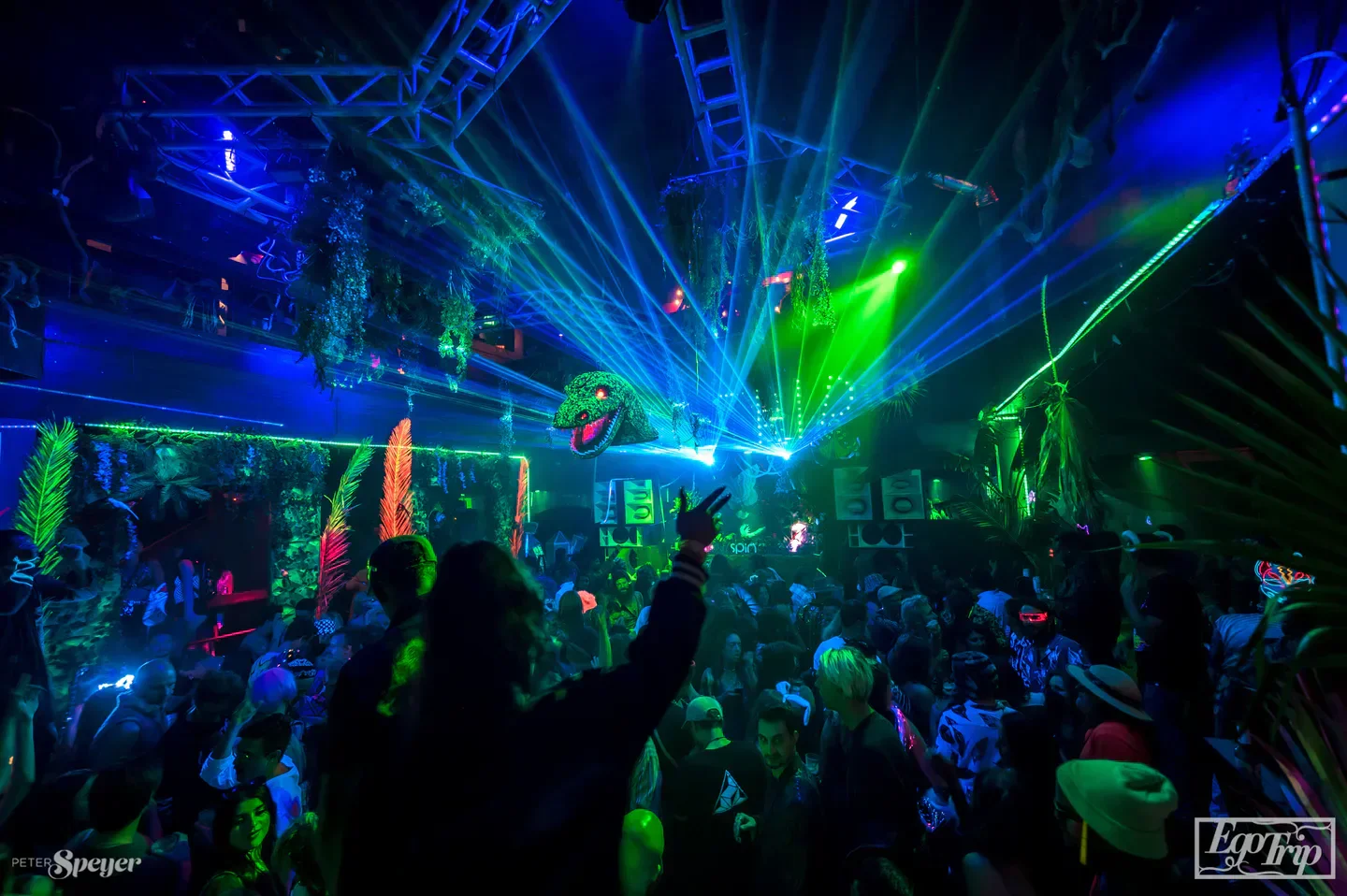 Energetic dance floor at Spin San Diego nightclub with laser lights and lively crowd.
