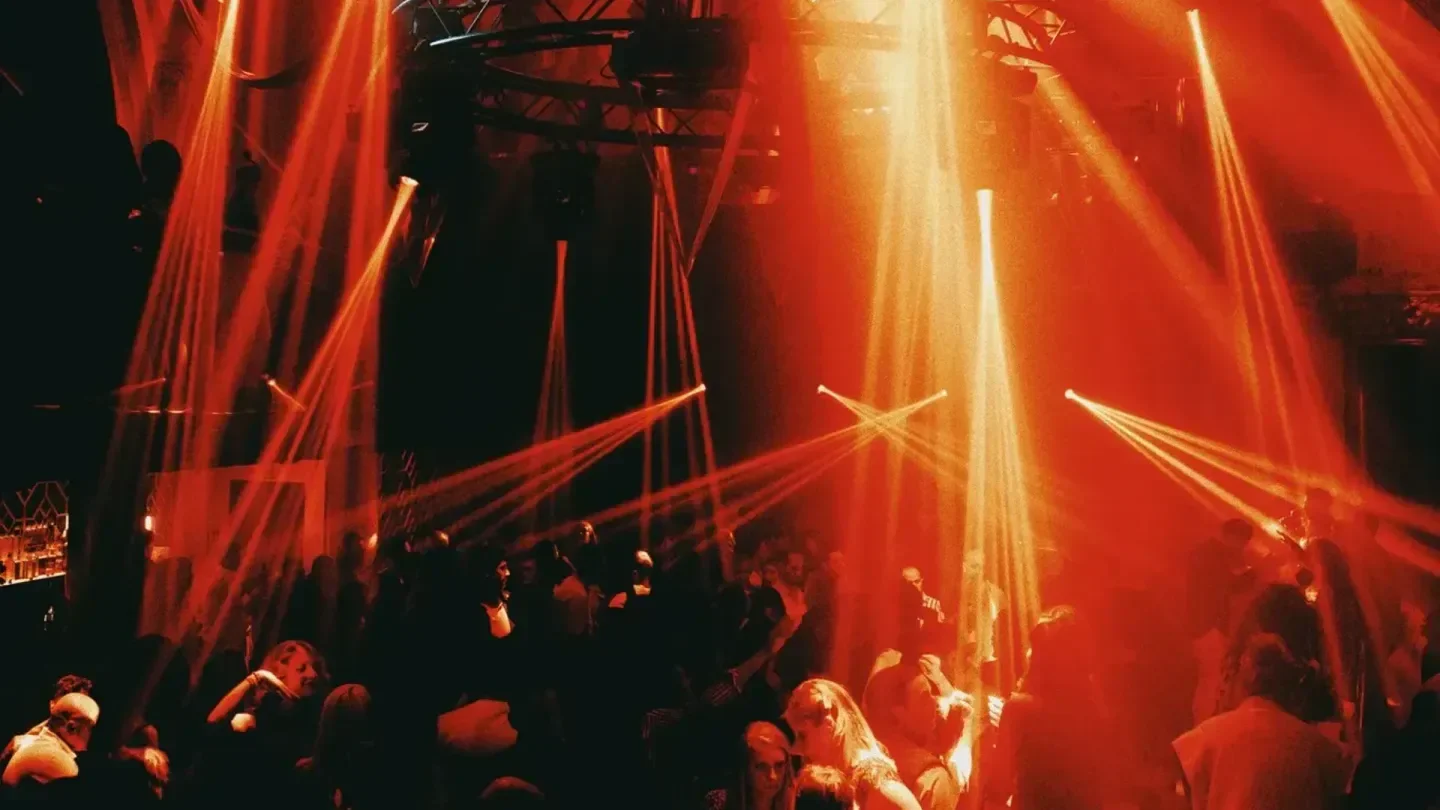 Energetic dance floor at Spirito Brussels nightclub in Brussels, illuminated by vibrant red lights.