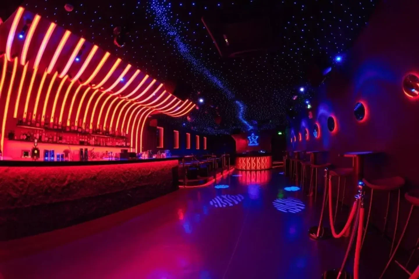 Inside Stardust nightclub in Shanghai, with red and blue neon lights and bar.