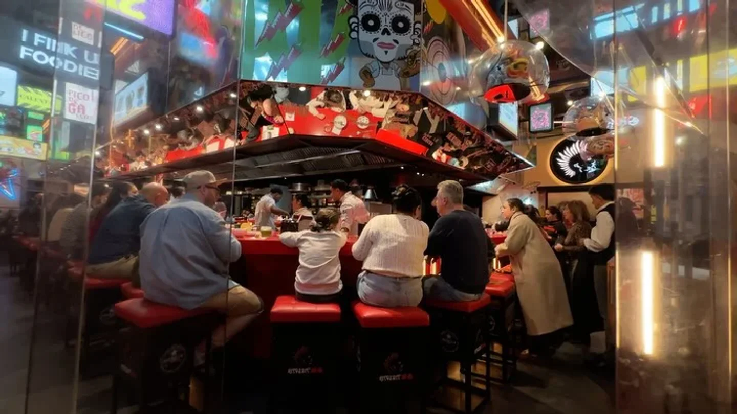 StreetXO restaurant interior with vibrant decor and patrons seated at the bar in the city.