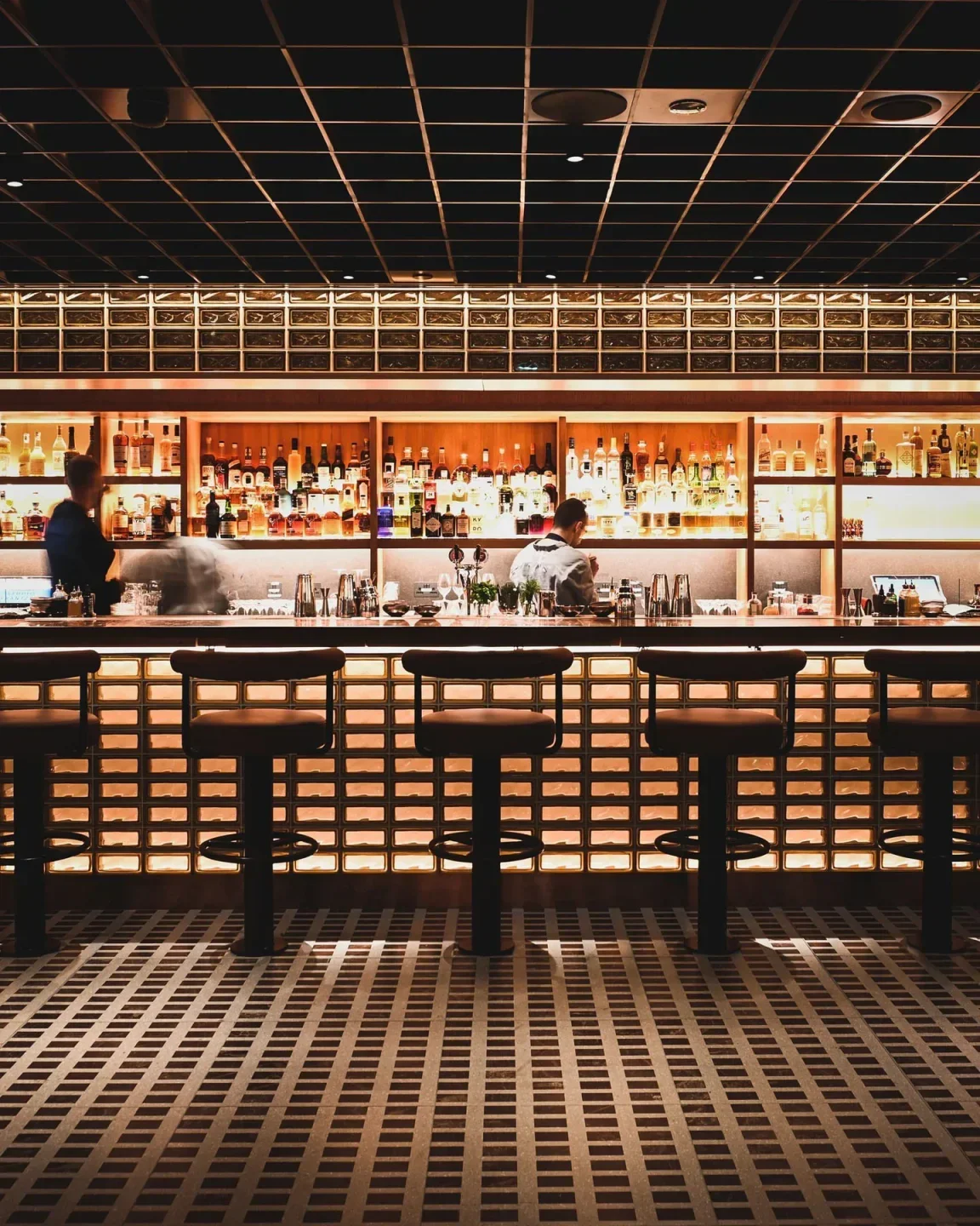 Interior of Studio Frantzén restaurant in London, with bar stools and bottles