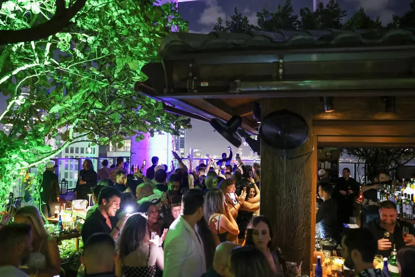 Sugar Miami rooftop bar with city views, vibrant nightlife scene with many people.