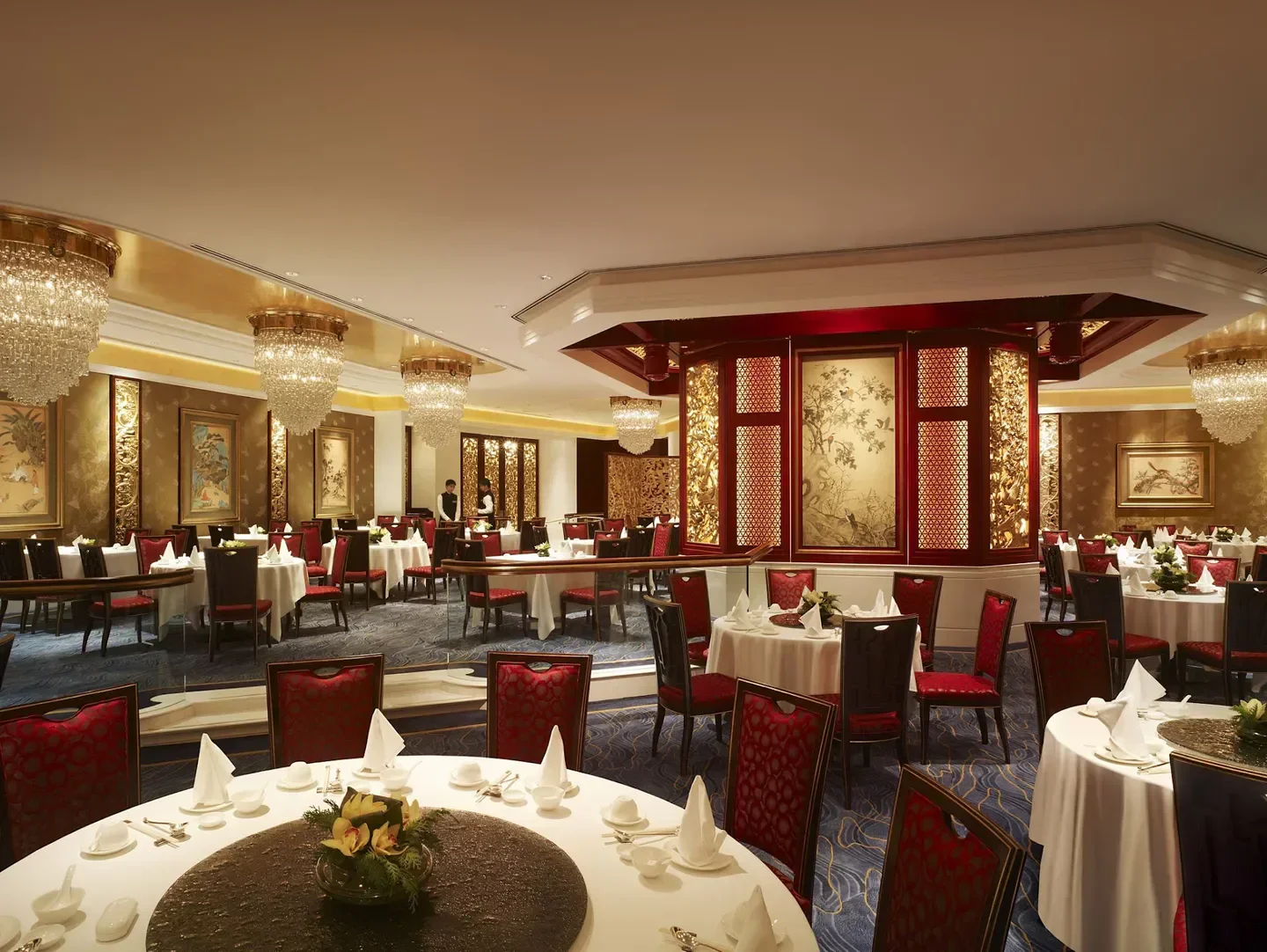 Elegant dining room interior at Summer Palace restaurant in Hong Kong, with crystal chandeliers.