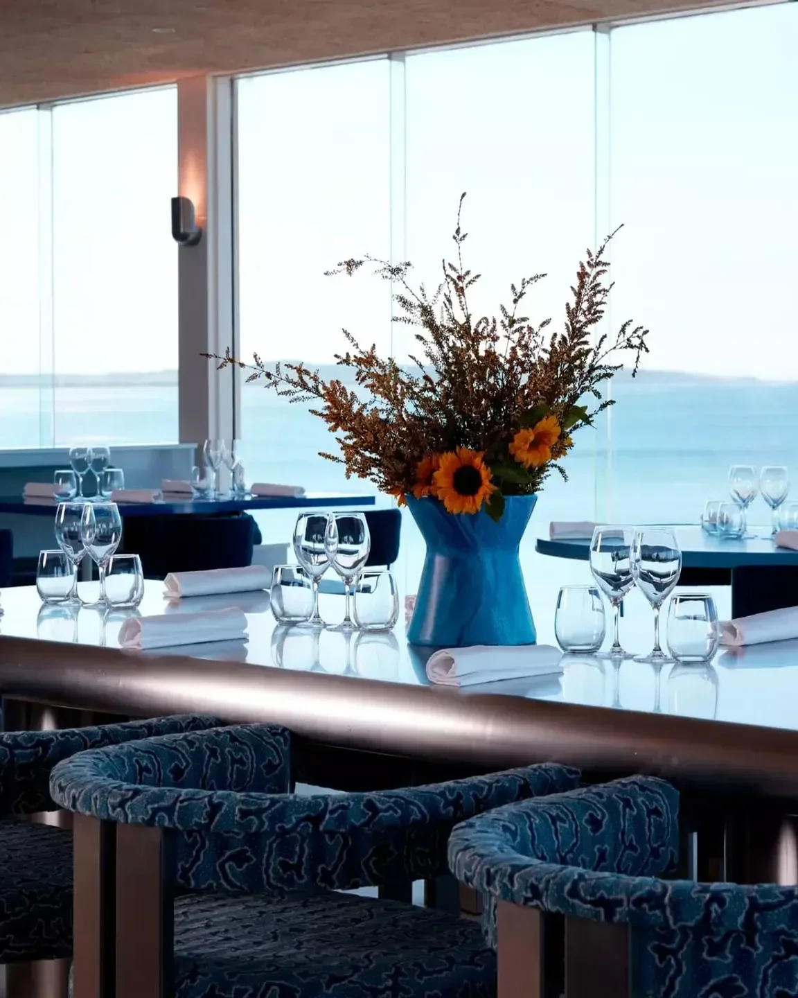Dining experience at Summer Salt in Sydney with stunning ocean views and floral centerpiece.