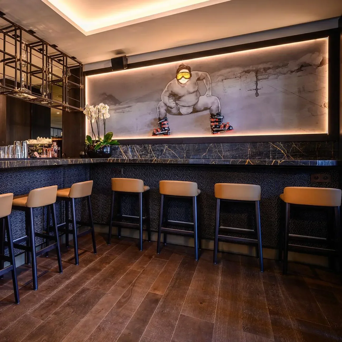 Interior of Sumosan Courchevel restaurant with a unique mural and stylish bar seating.