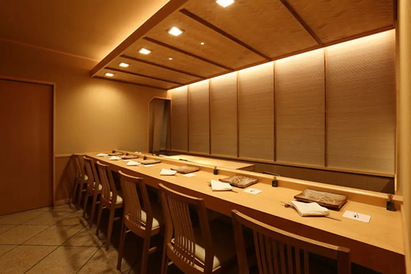 Interior of Sushi Iwa in Tokyo with wooden decor and sushi bar seating.