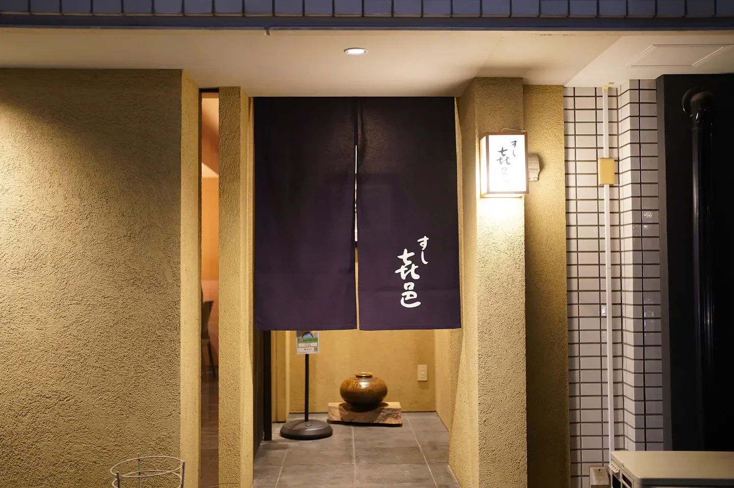Entrance to Sushi Kimura restaurant in Tokyo, featuring a traditional noren curtain.