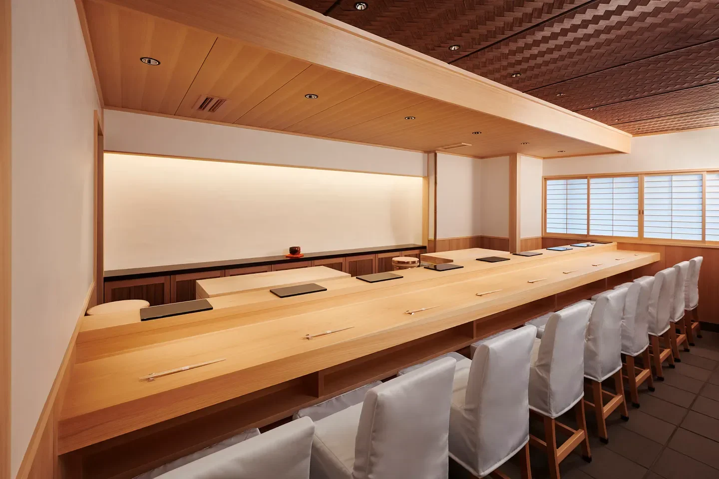 Elegant dining space at Sushi Masashi in Tokyo, featuring a long wooden counter and seating