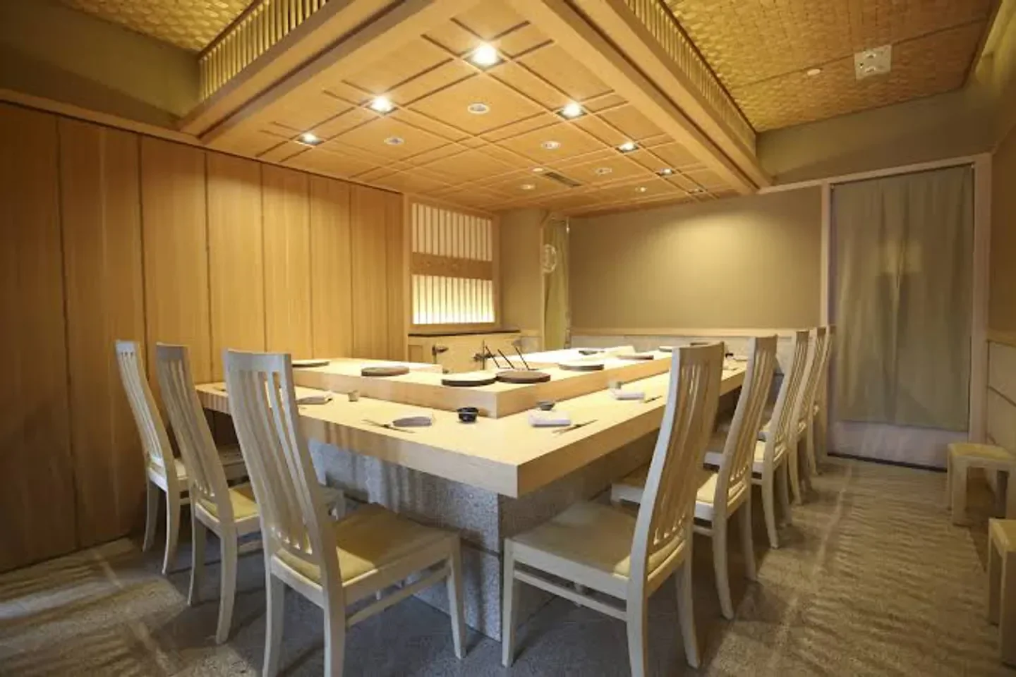 Interior view of Sushi Saito restaurant in Hong Kong, with a large wooden table.