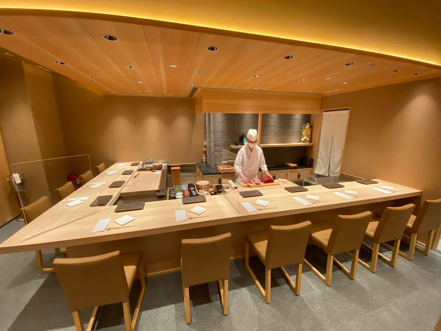 Chef at work in Sushi Wadatsumi Hong Kong, preparing fresh sushi at the counter.