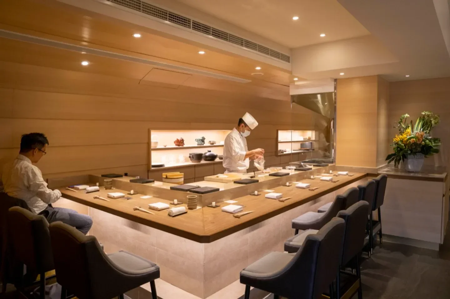 Chef preparing sushi at Sushiyoshi Taipei, a stylish restaurant with a minimalist design.