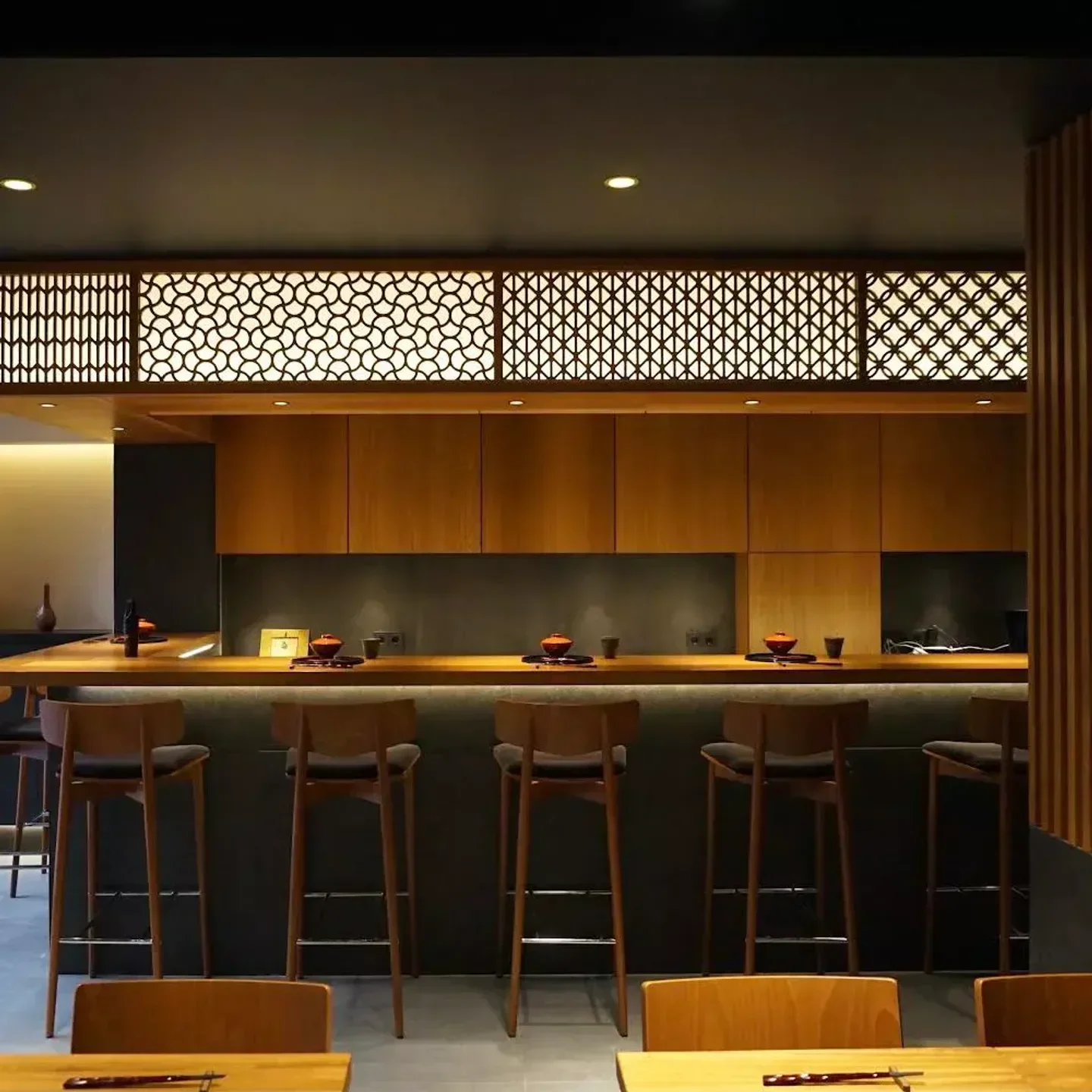 Interior of Suto in Barcelona: wooden bar with stylish chairs and decor.