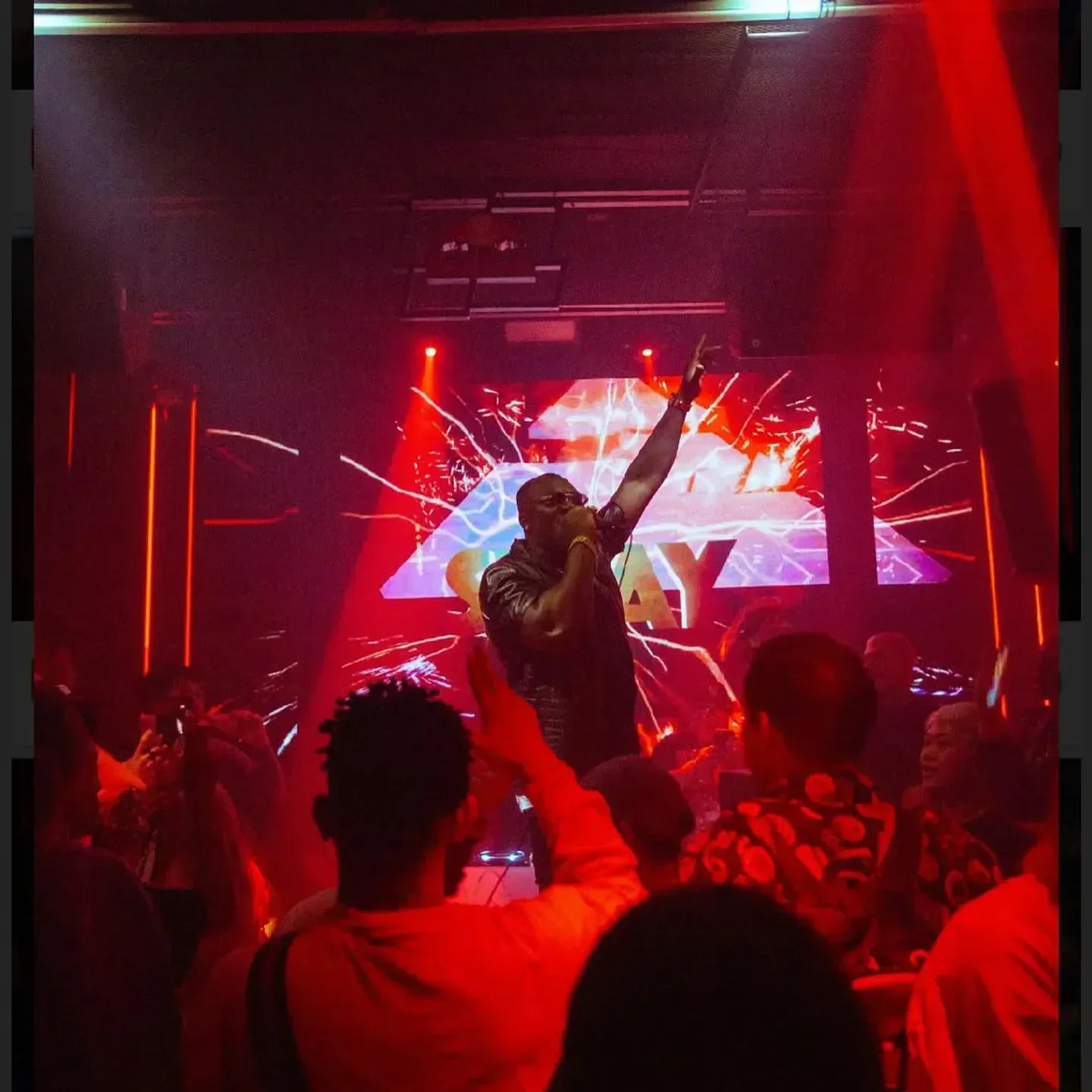 Energetic performance at SWAY nightclub in Bangkok. Crowd enjoying a live show under red lights.