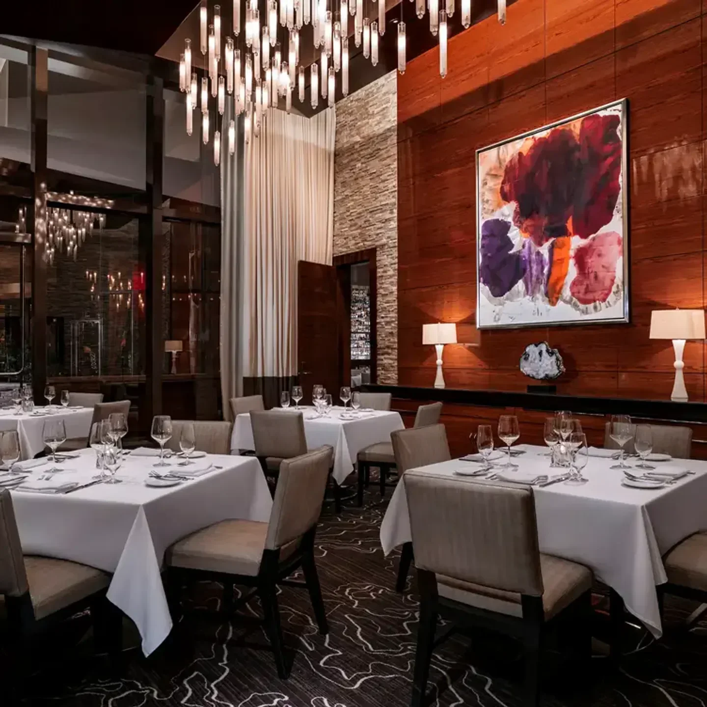 Elegant dining room interior at T-Bones restaurant in Las Vegas, with art and tables.