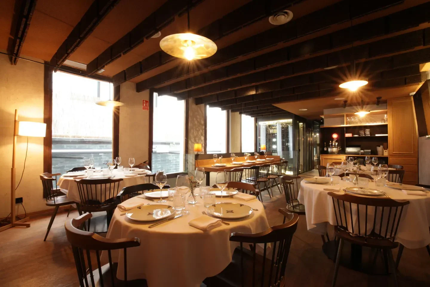 Cozy dining area at Taberna Pedraza, a restaurant in Madrid, Spain, with elegant tables.