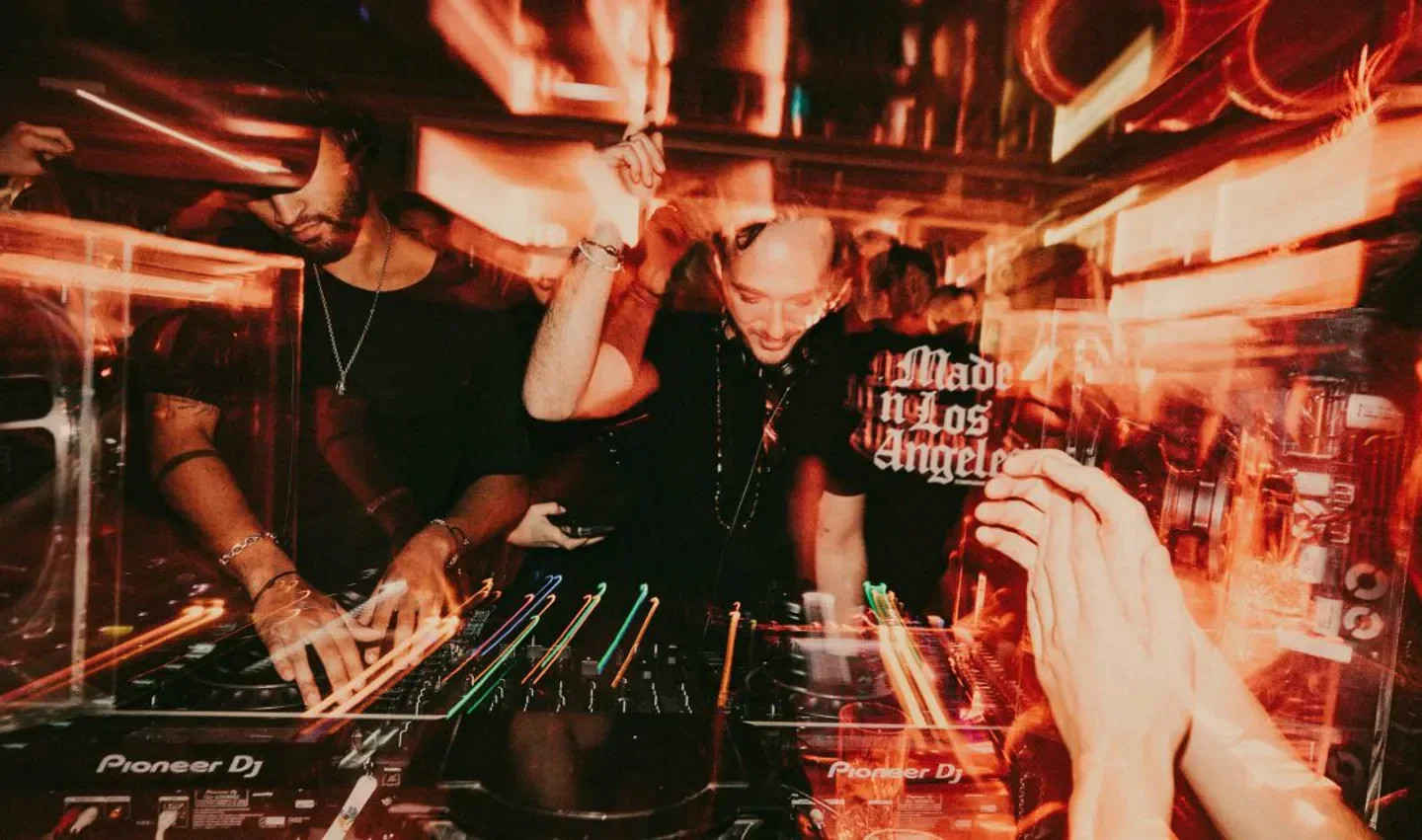 Energetic DJ performance at Taboo nightclub in Paris with vibrant lighting and lively atmosphere.