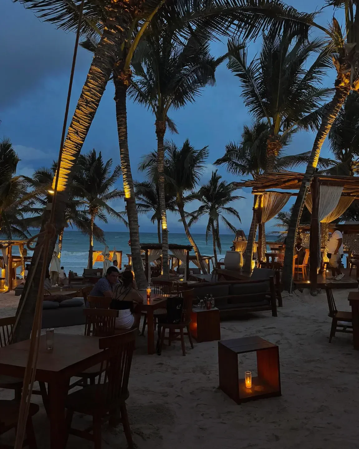 Taboo Tulum restaurant at night with palm trees and ocean view