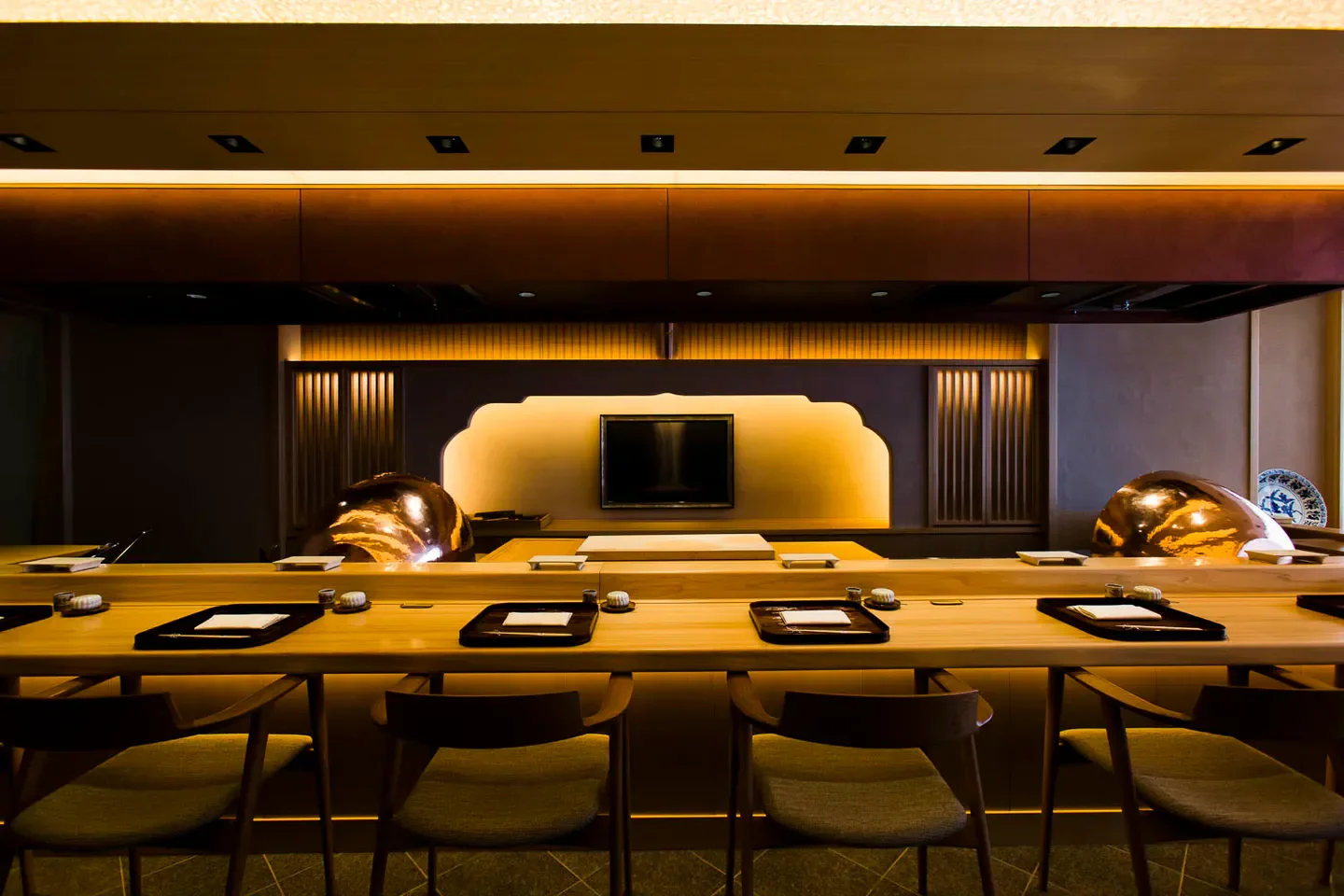 Interior of Takiya Tempura in Tokyo, featuring a minimalist design and warm lighting.