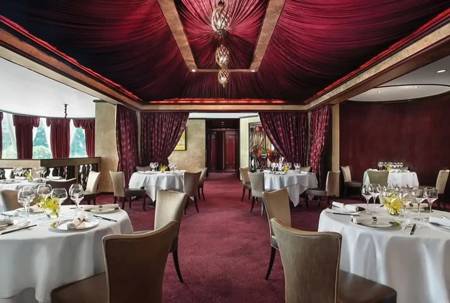 Elegant dining room at T'ang Court, Hong Kong with round tables and opulent decor.