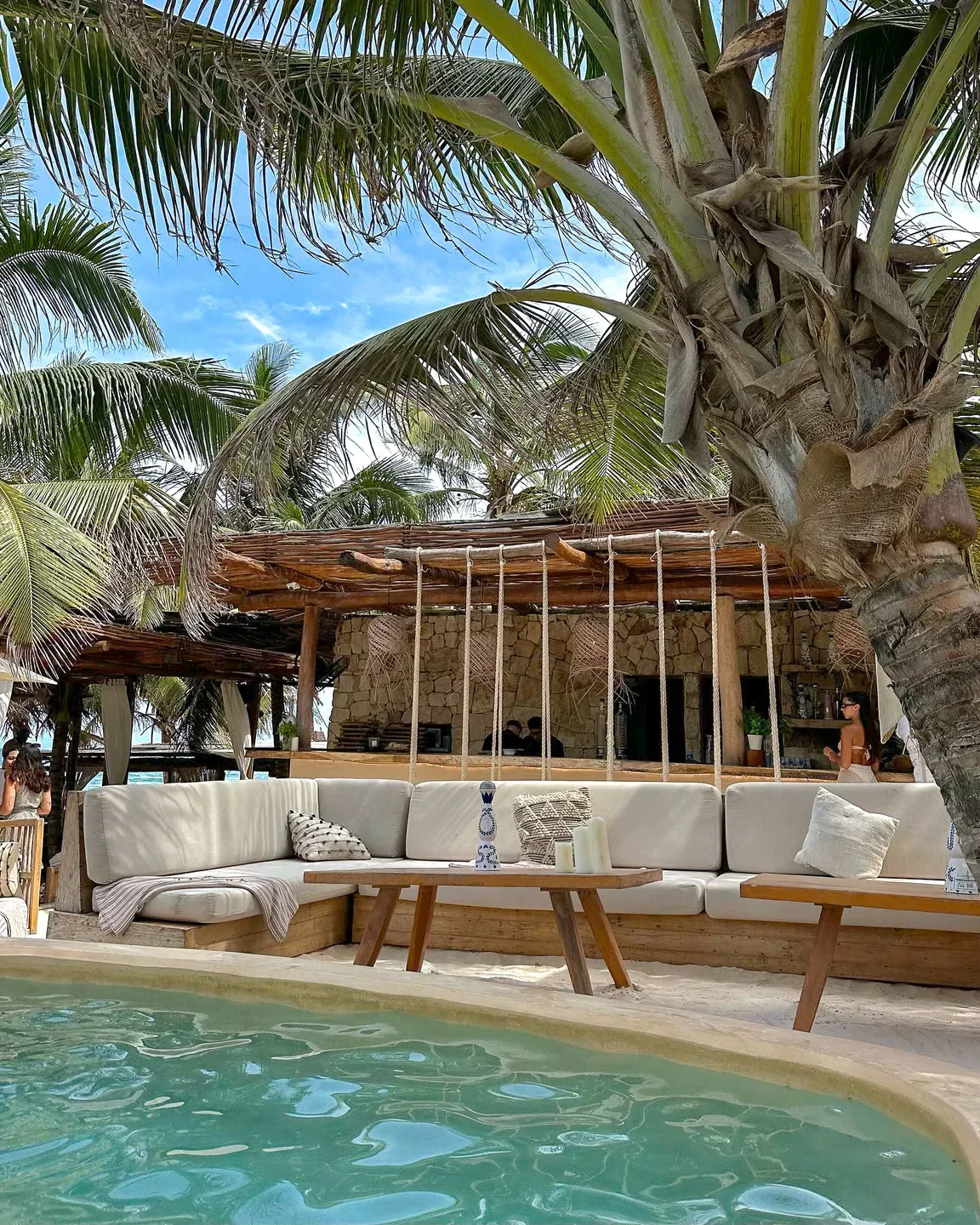 Tantra Tulum restaurant: Stylish lounge area with pool, tropical palms and a stone bar.