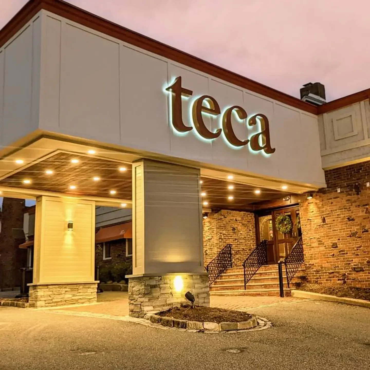 Exterior view of Teca Newtown Square restaurant in Philadelphia at dusk, with inviting entrance.