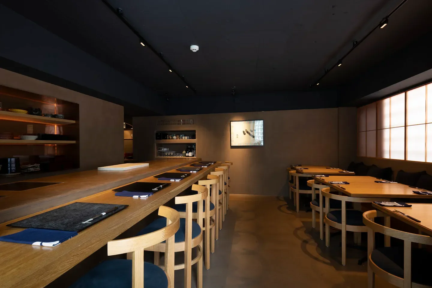 Interior of Tenoshima restaurant in Tokyo, featuring a minimalist bar and dining area.