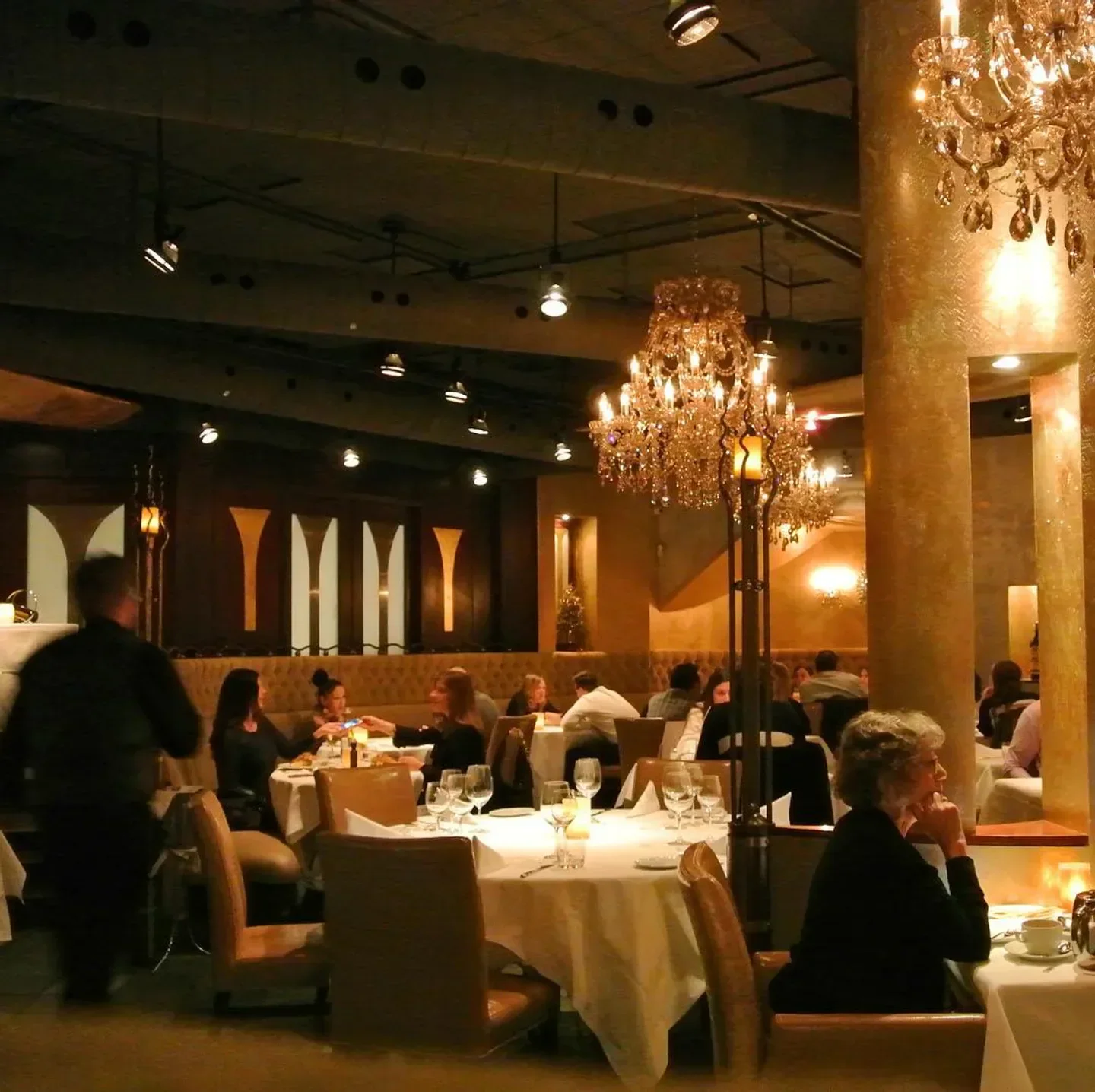 Elegant dining room at Terra Restaurant in Toronto, with chandeliers and tables set.