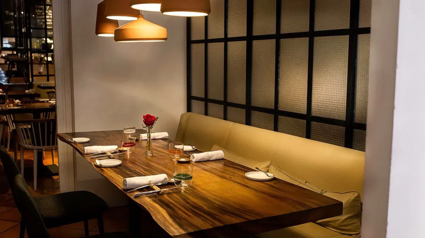 Terra Singapore restaurant's elegant dining area with wooden table and rose centerpiece.