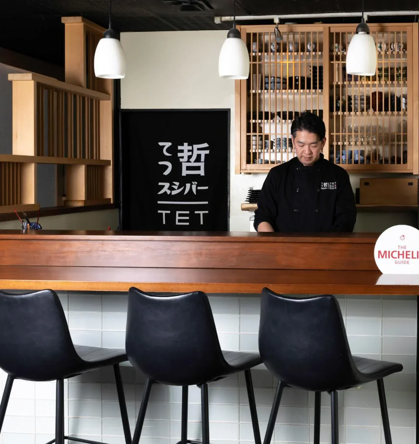 Chef at the bar in Tetsu Sushi, Vancouver. Michelin Guide restaurant with stylish interior.