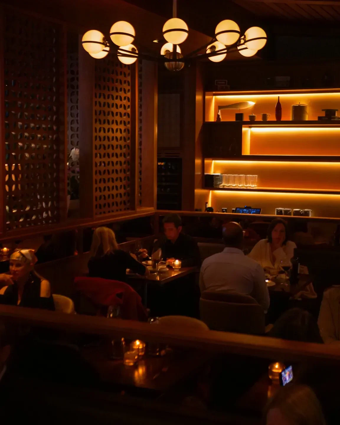 Cozy dining area at The Arthur J restaurant in Los Angeles, featuring warm lighting.