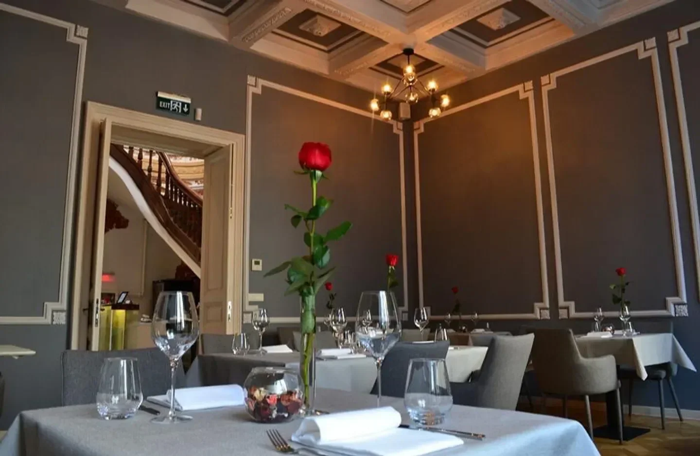 Elegant dining room at The Artist restaurant in Bucharest, featuring roses on the tables.