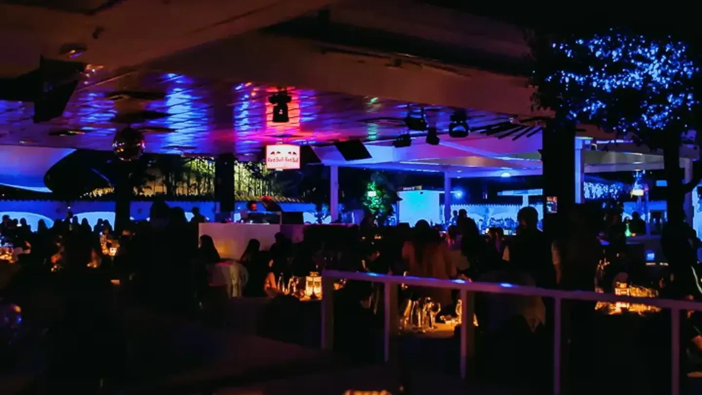 Night view of The Beach Club in Milan, with patrons enjoying a night out.