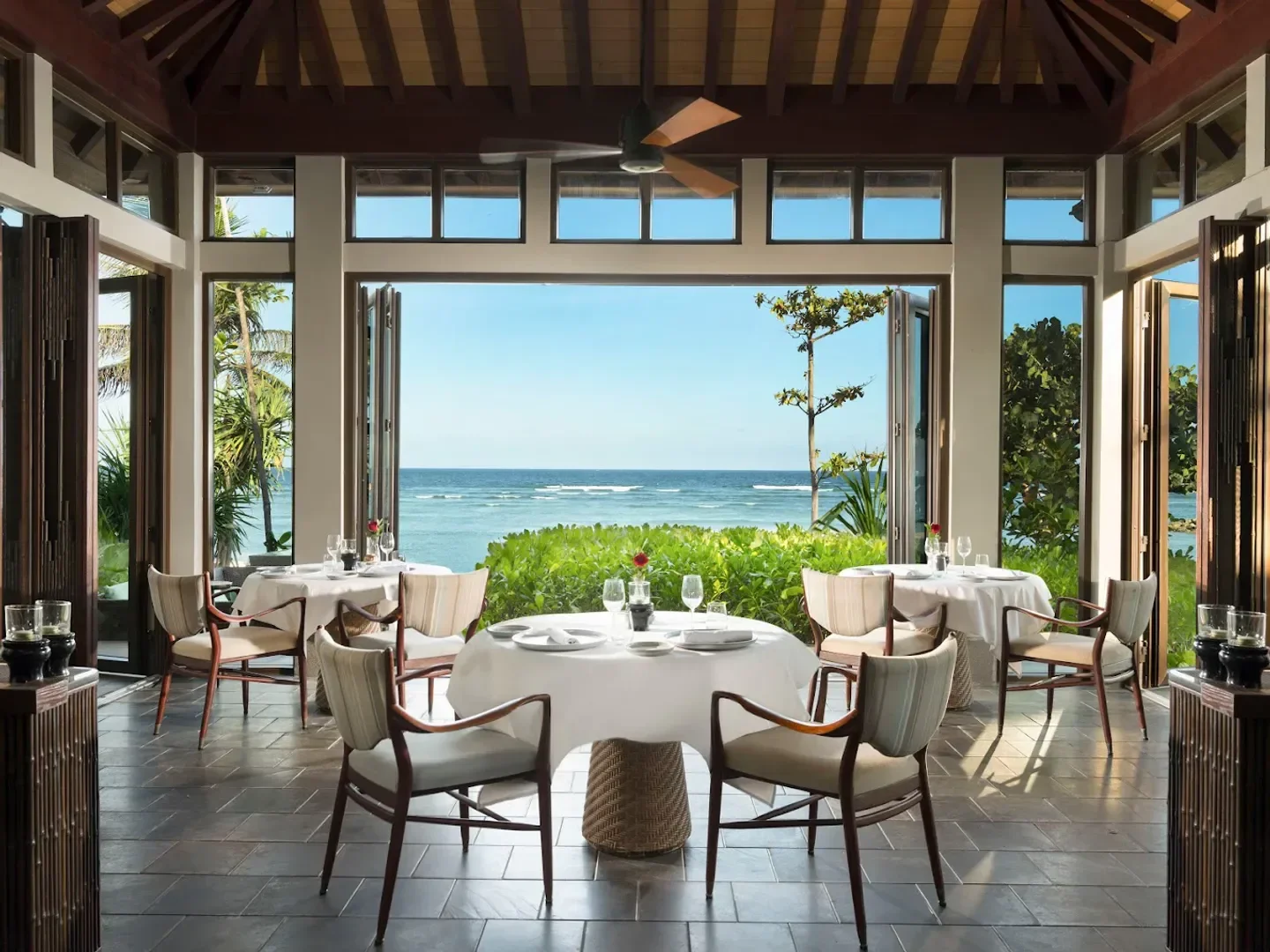 Elegant dining room at The Beach Grill in Bali, with ocean views and table settings.
